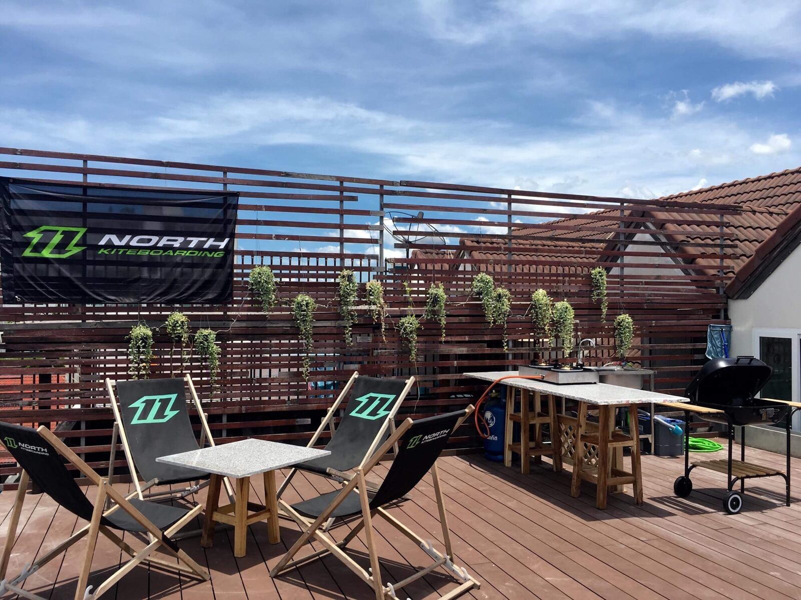 Rooftop deck with chairs, a grill, and an outdoor kitchen