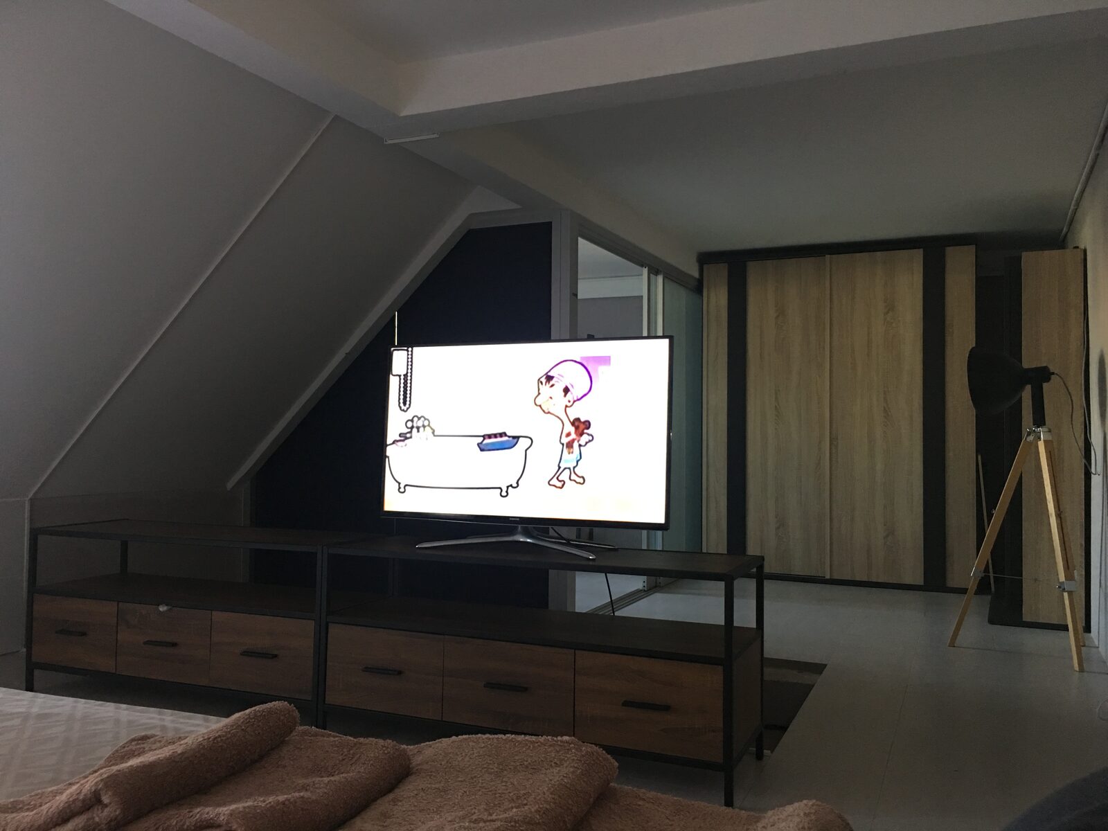 Rooftop Apartment living area with television and wardrobe